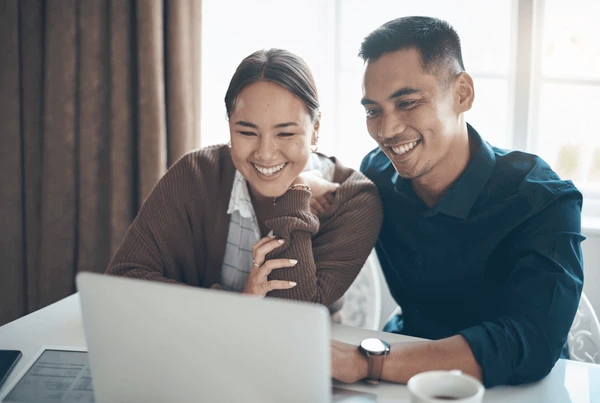 happy person reviewing insurance savings on a laptop